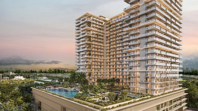 Sol Levante residential tower at dusk in Jumeirah Village Triangle, with its rooftop podium pool and palm-lined street