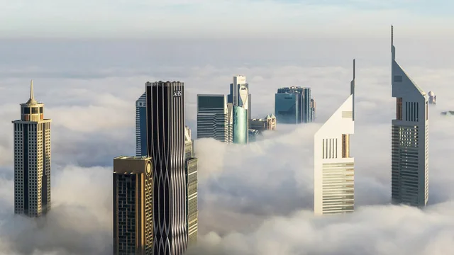 AHS Tower, a sculptural black commercial tower rising above the clouds on Sheikh Zayed Road beside Emirates Towers, Dubai