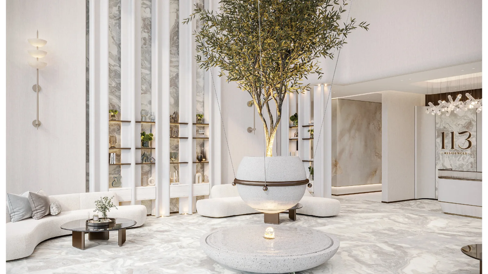 Double-height residents' lobby with a central olive tree and marble finishes at 113 Residences, Dubai