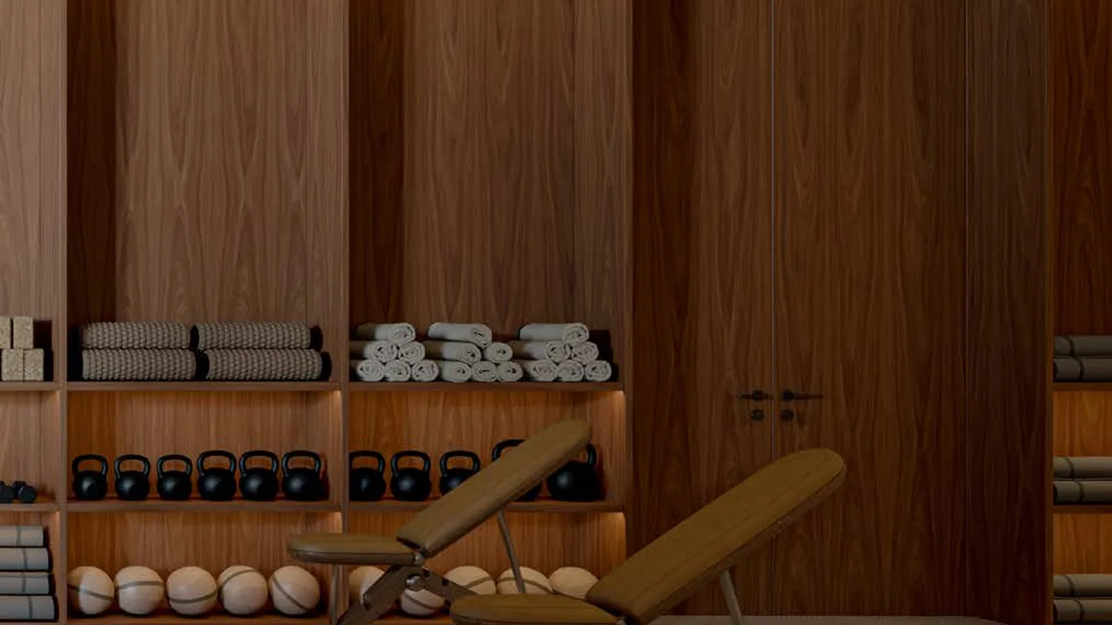 Indoor fitness room with exercise benches and weights at Tessera by Al Ghurair.